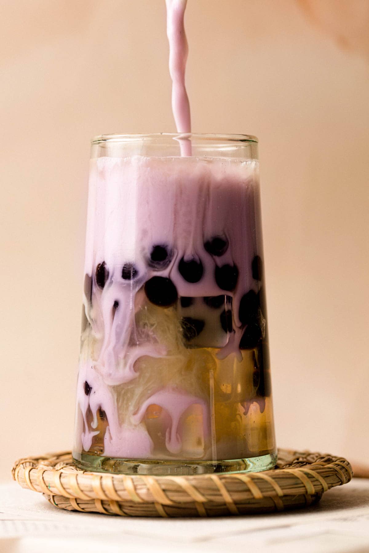 Taro milk bubble tea in a large glass.