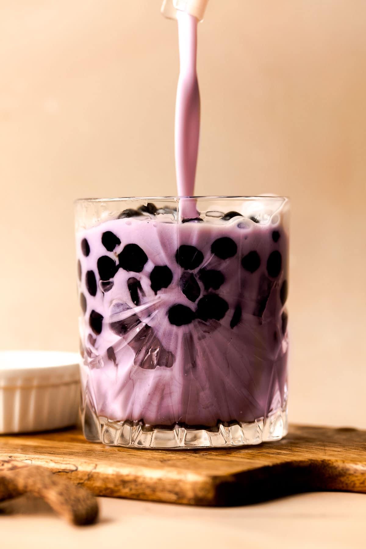 A stream of taro smoothie pouring into a glass.
