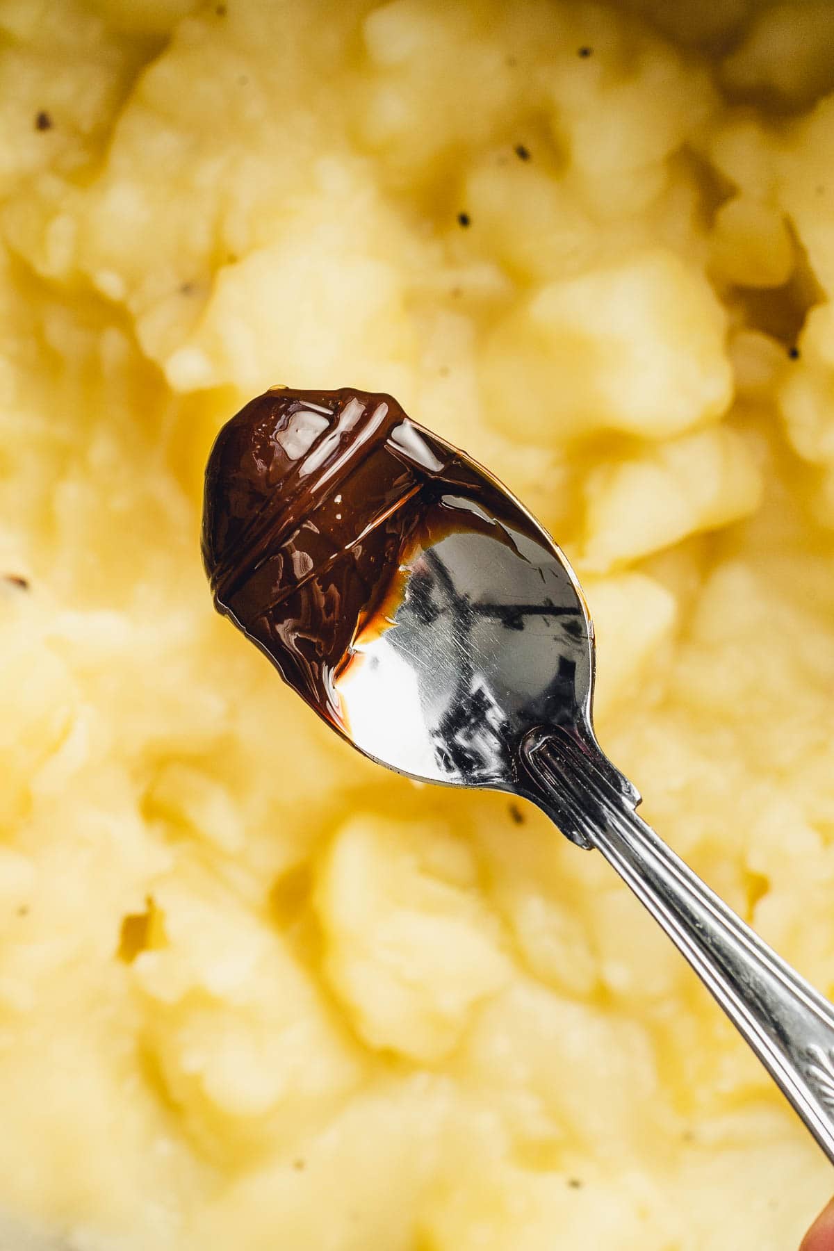 A spoon of marmite on top of stewed potatoes.