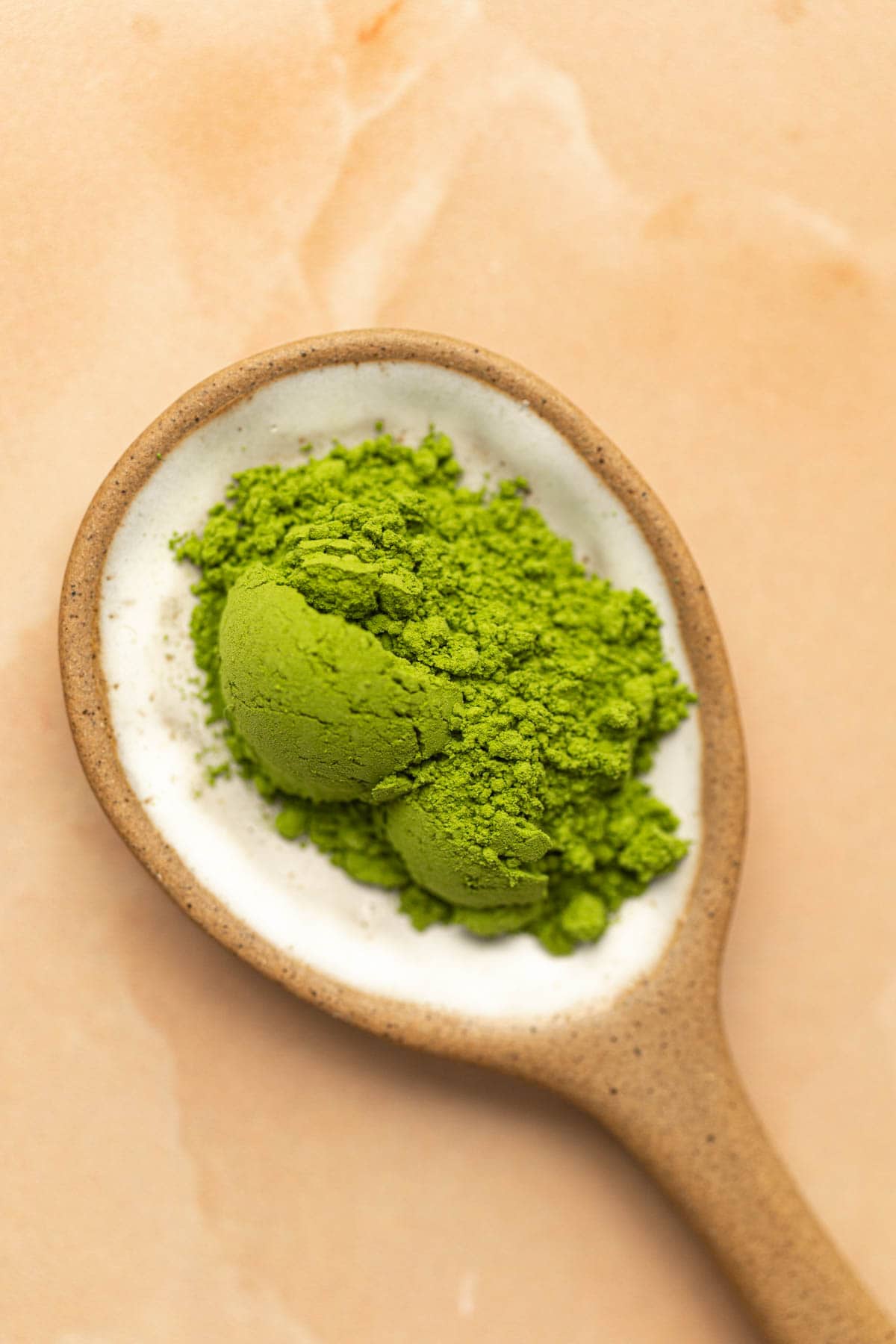 A spoon containing matcha powder.