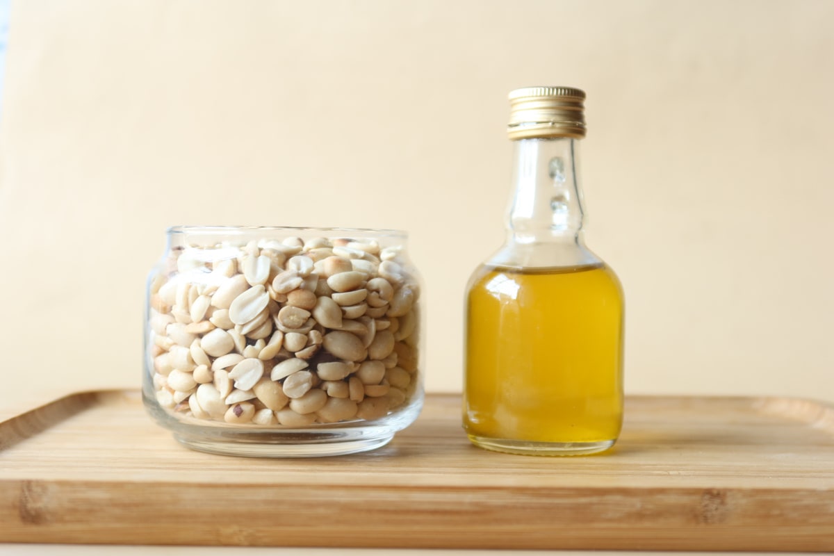 Peanuts in a jar and oil in a container.