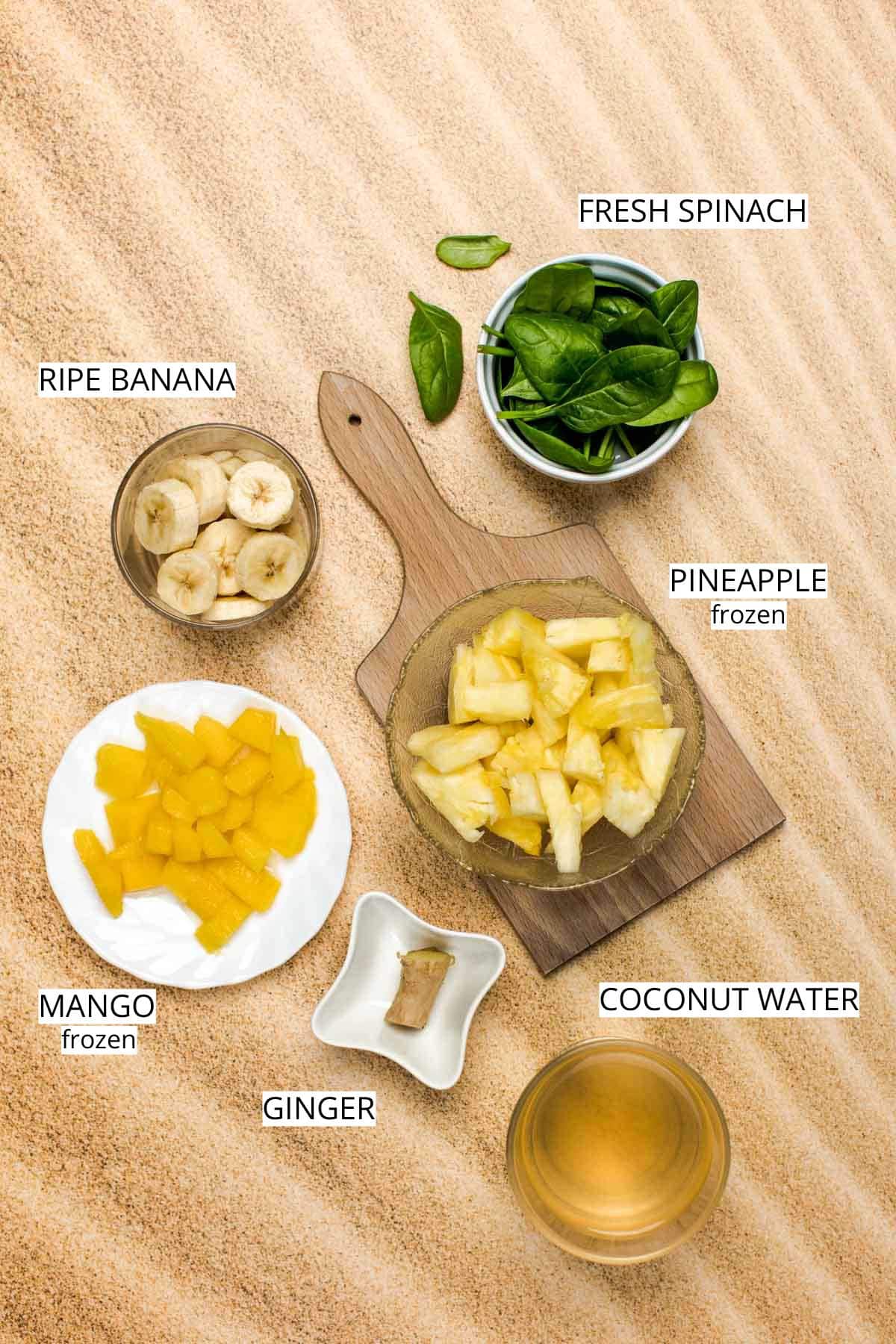 All ingredients needed to make a green smoothie laid out on a surface.