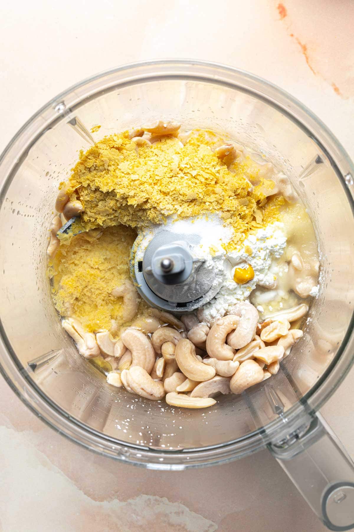 Cashews and other vegan cheese ingredients in a food processor.