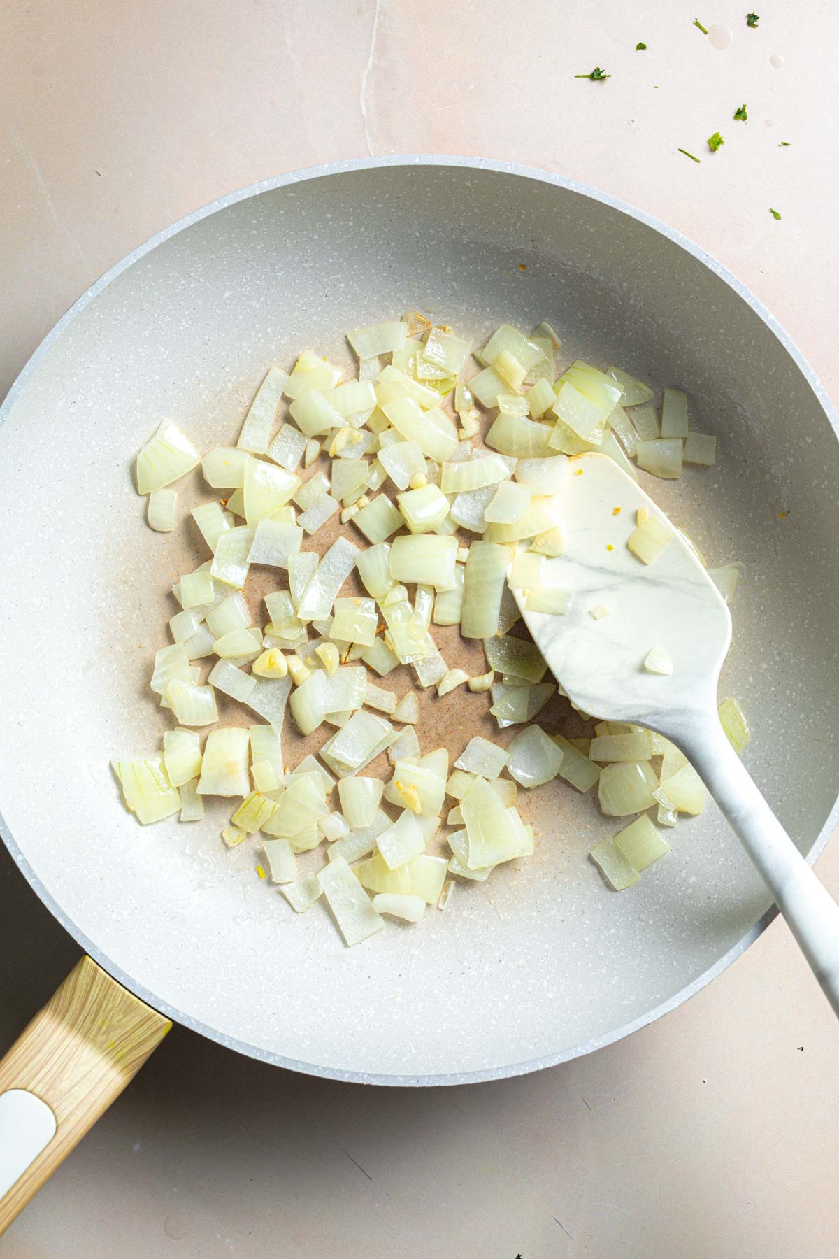 Onion and garlic being sautéed in a pan