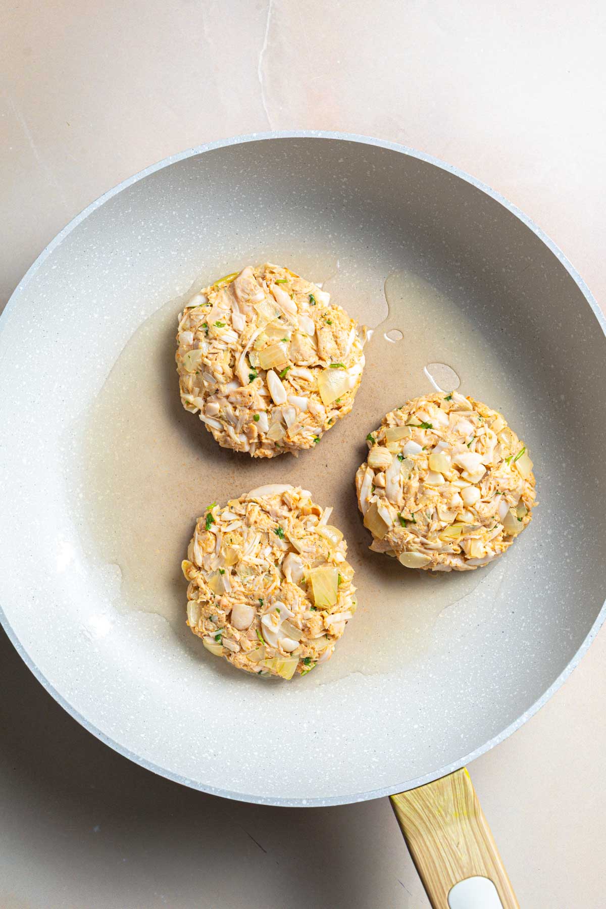 Three jackfruit burgers in a pan unbaked