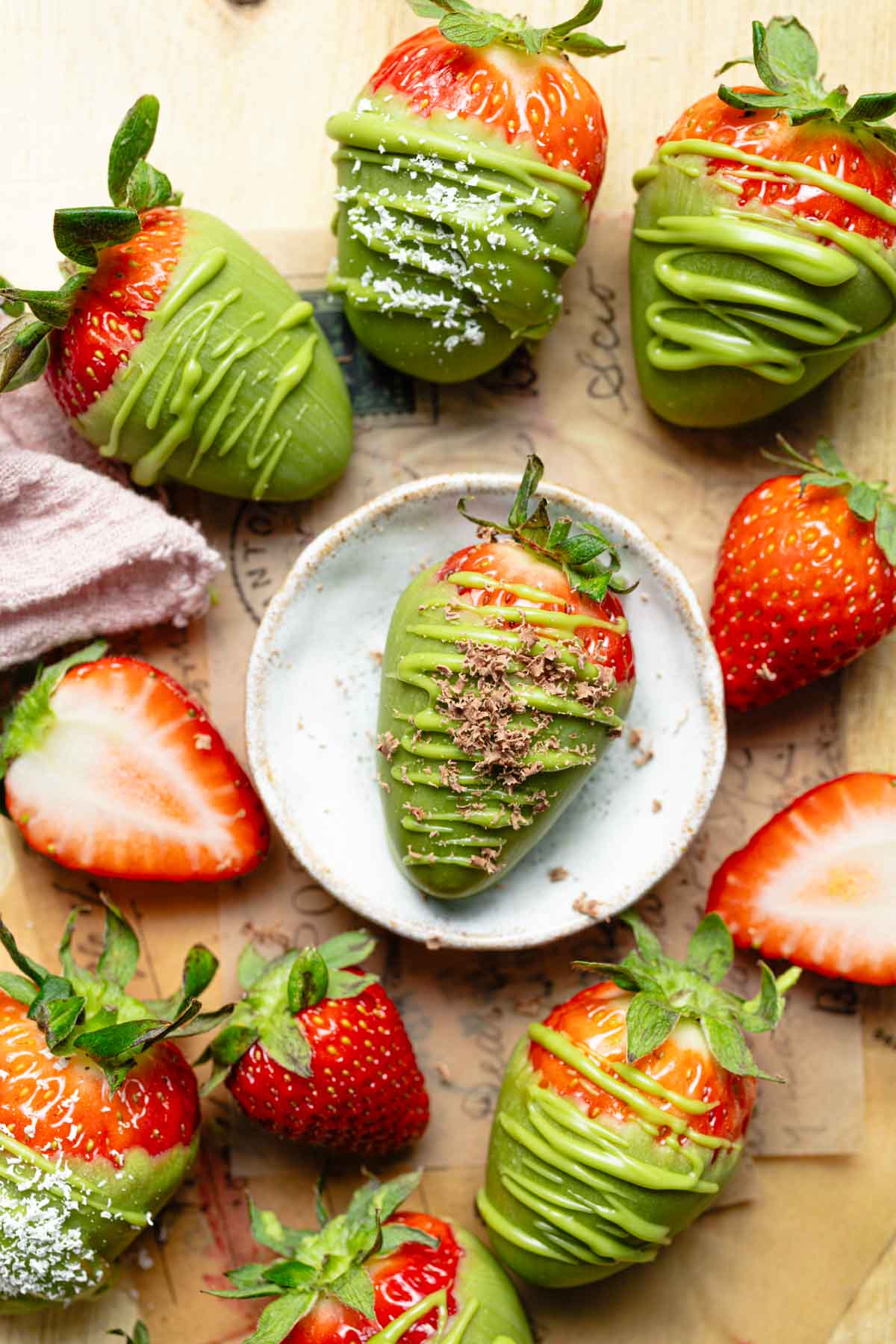 Several matcha strawberries on a wooden board