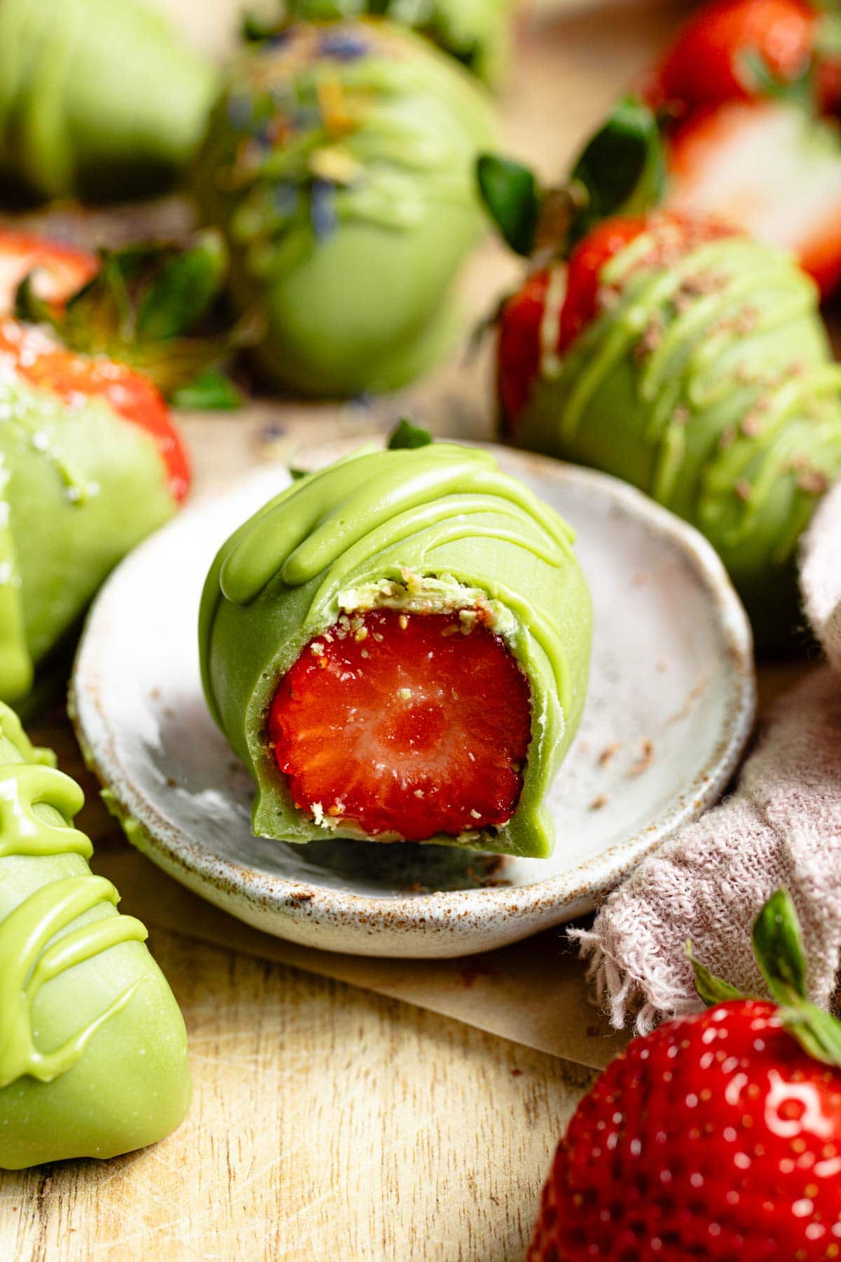 A matcha strawberry with a bite taken out