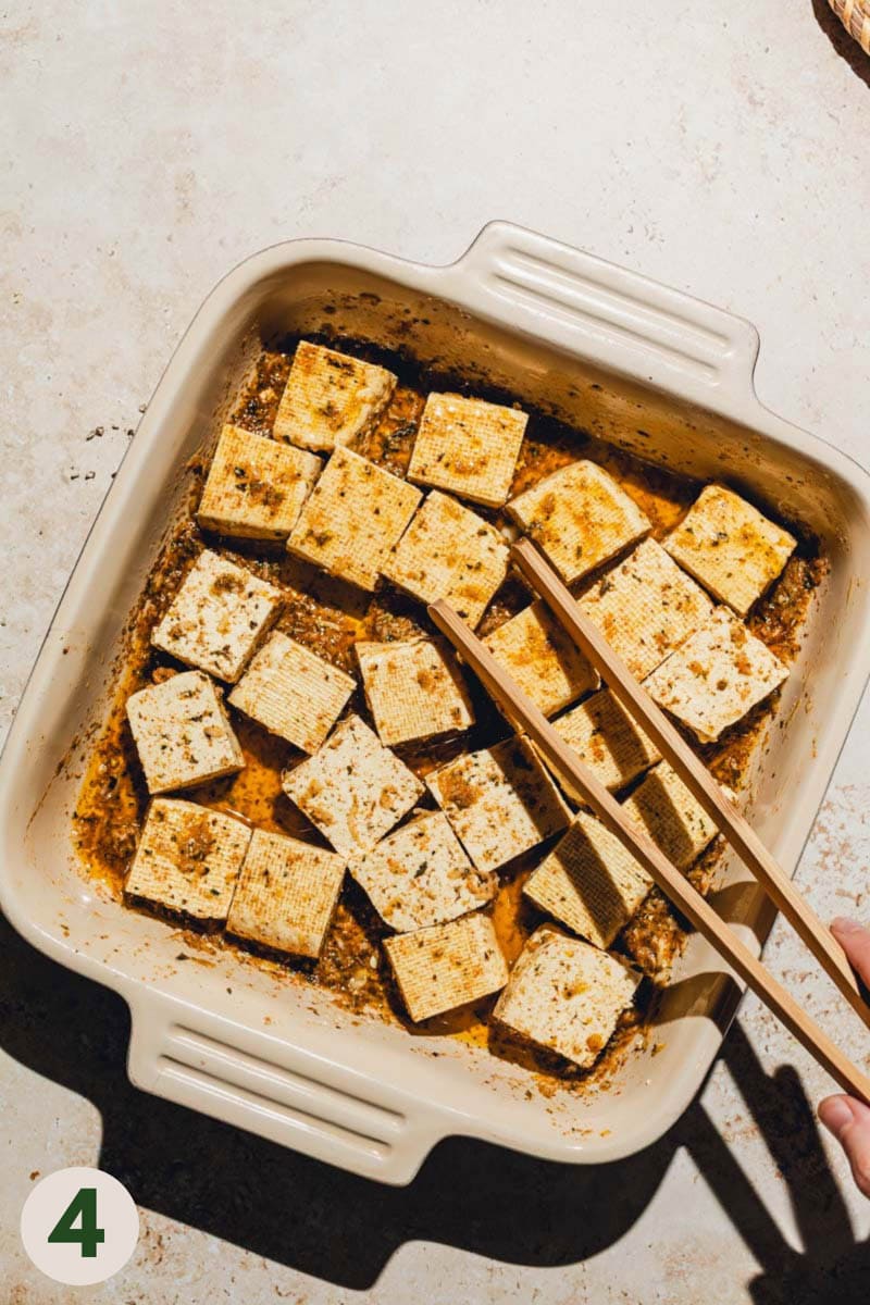 Wooden tongs reaching out for tofu