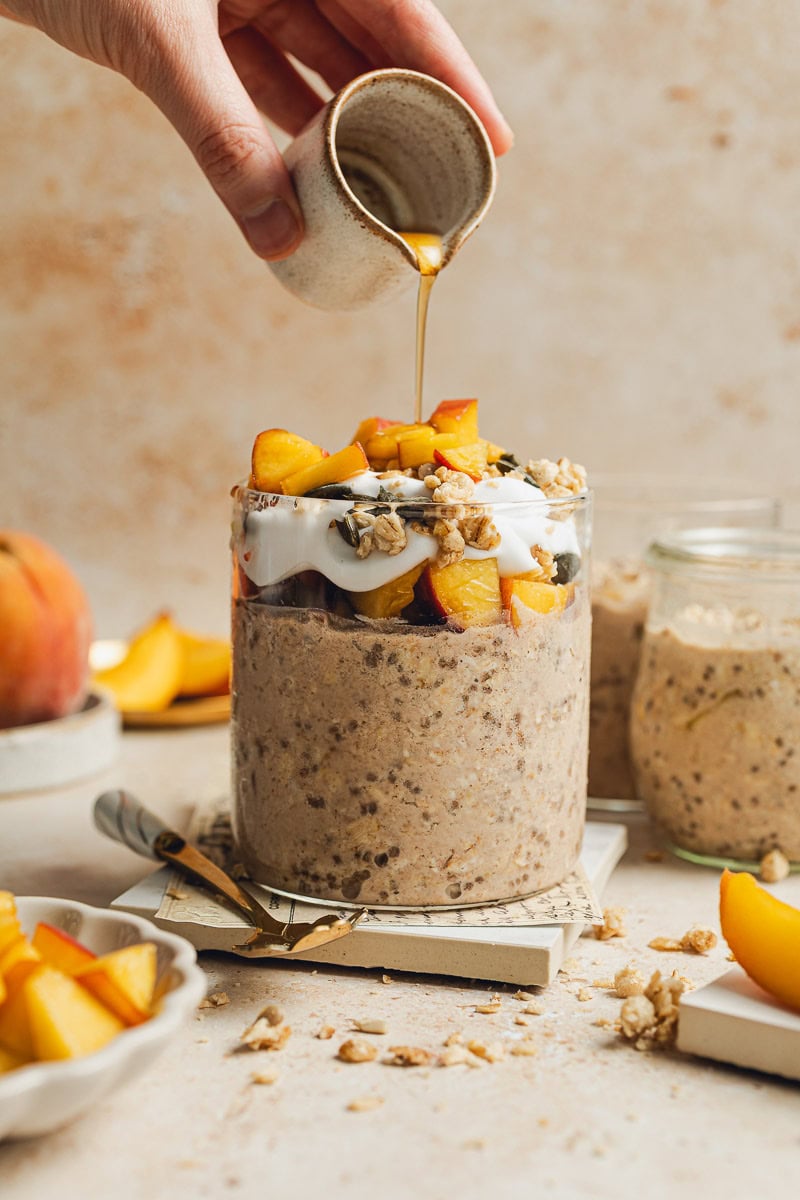 Maple syrup being drizzled overnight oats