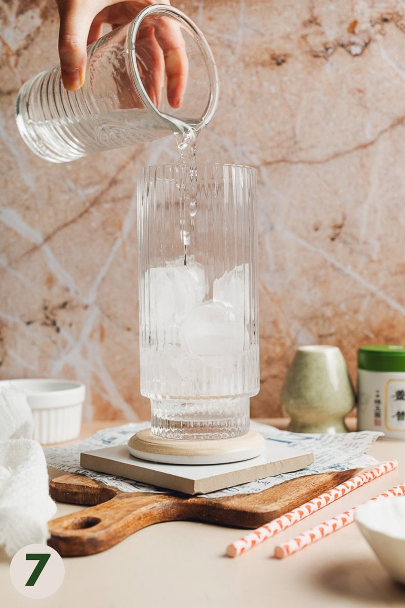Water being poured into a glass of ice
