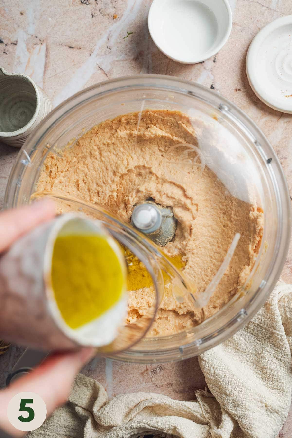 Olive oil being added to food processor