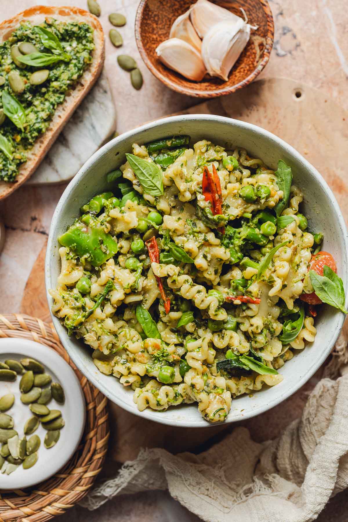 A bowl of pesto pasta with veggies