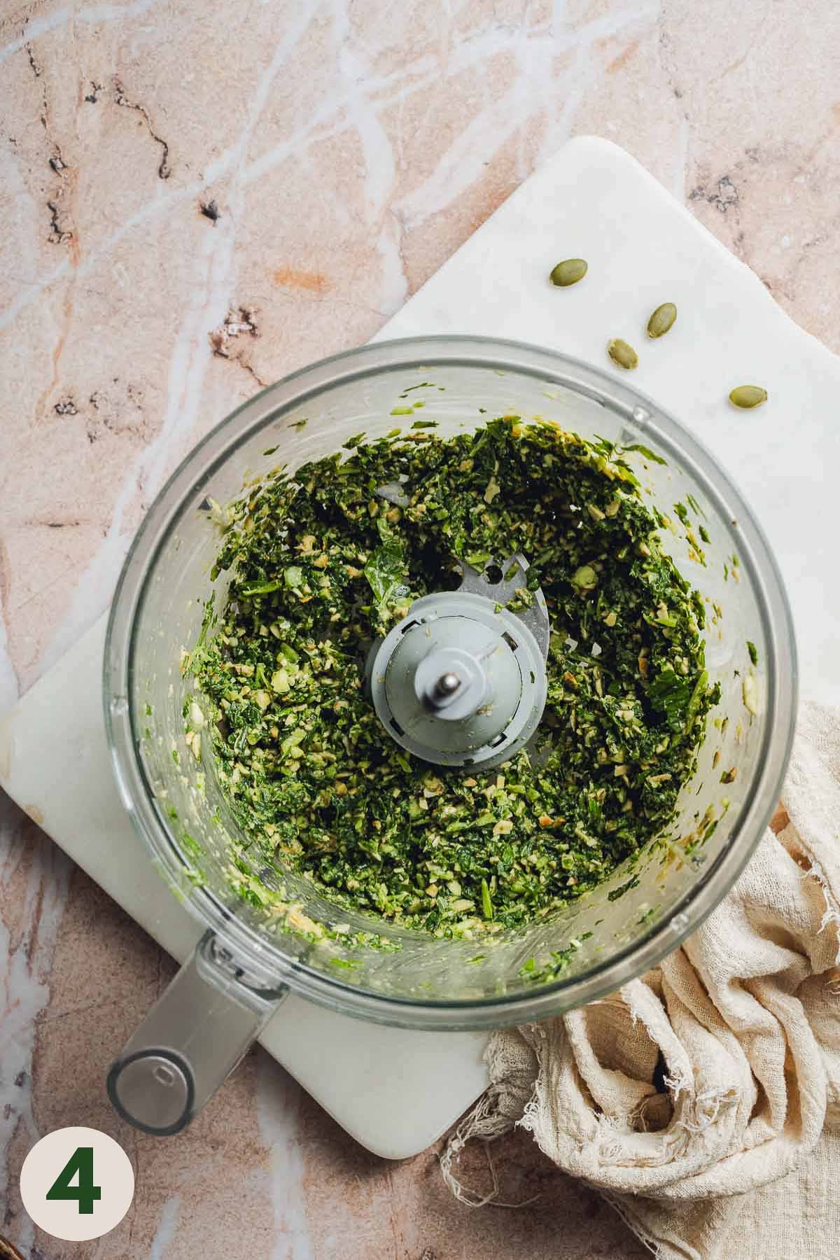 A food processor containing pesto