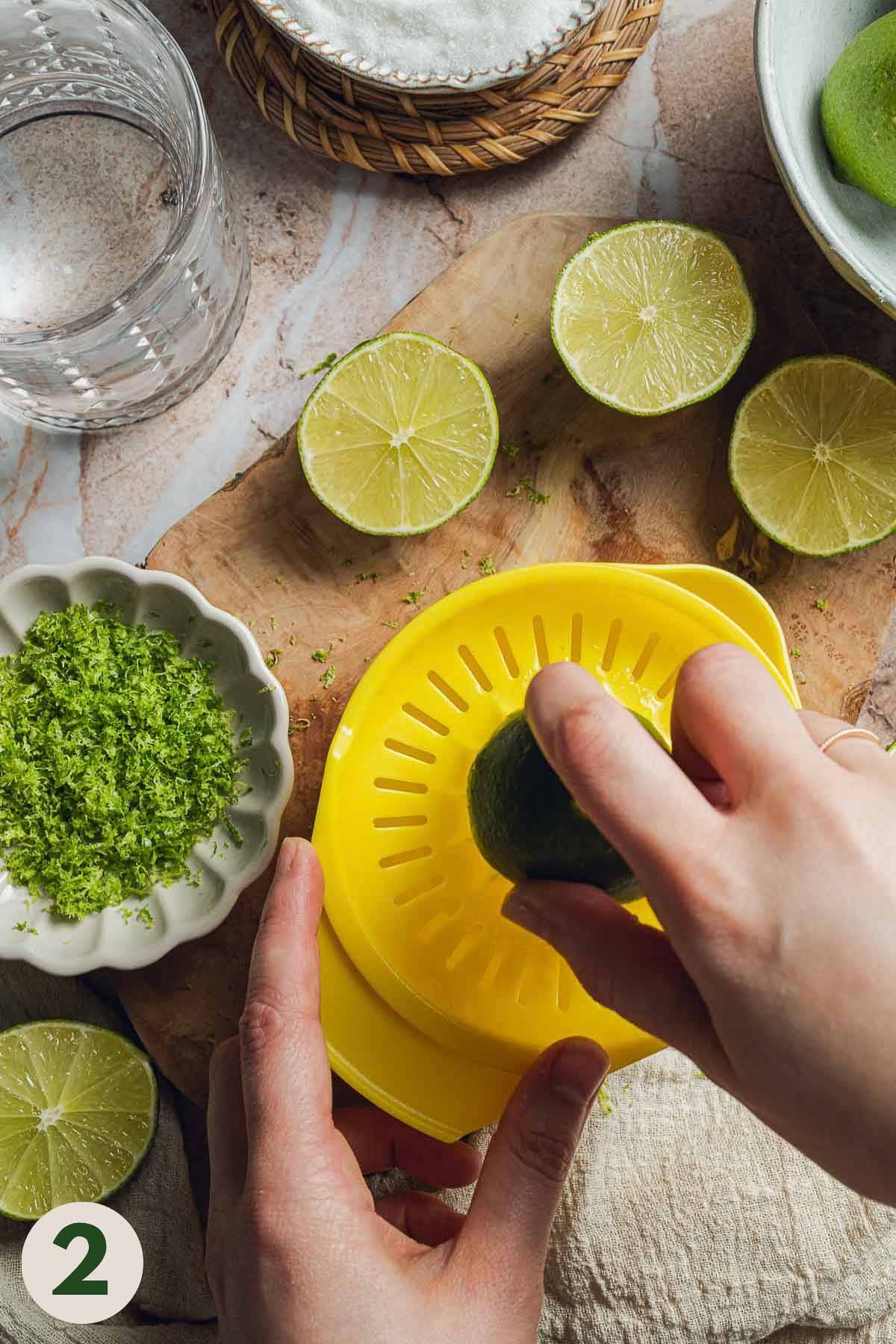 Hands juicing limes with a citrus juicer