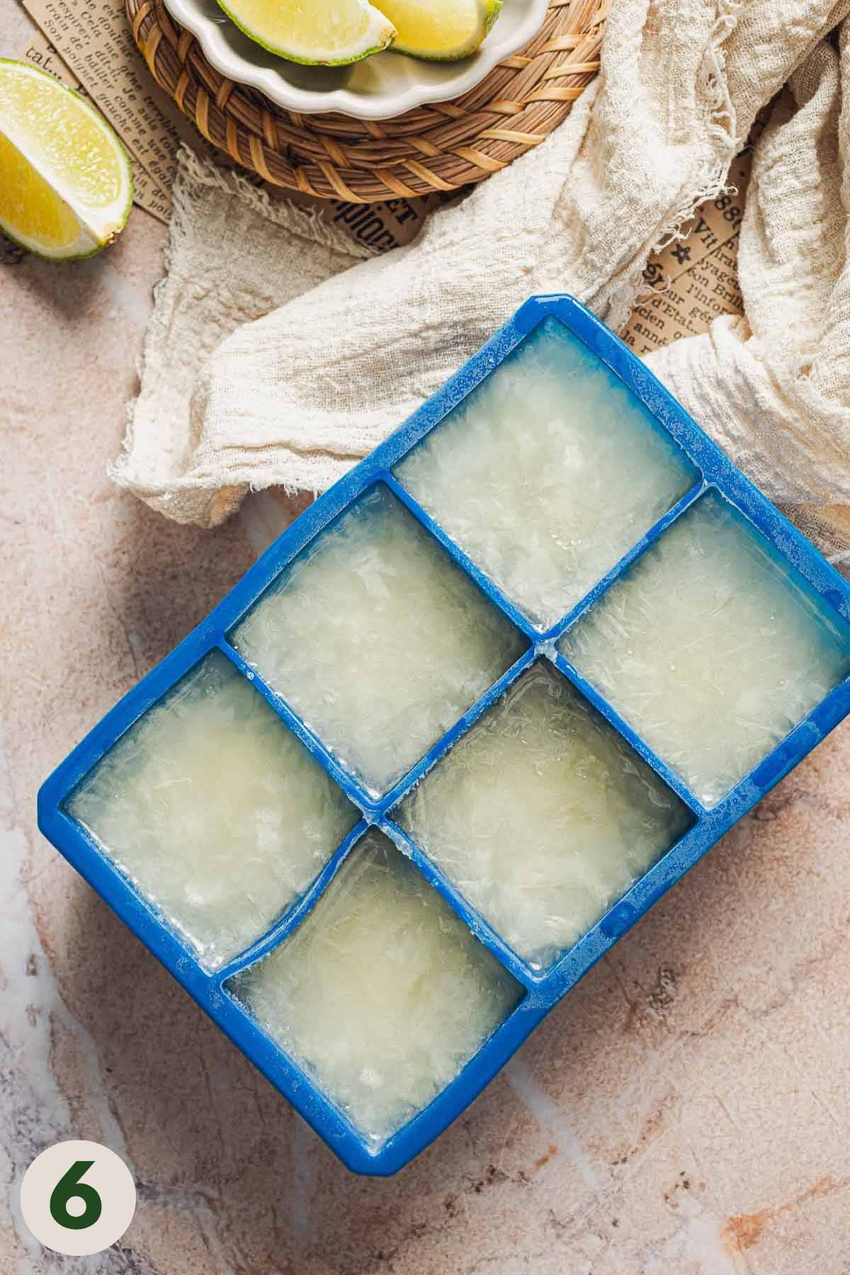 Ice cube tray filled with frozen limeade concentrate.
