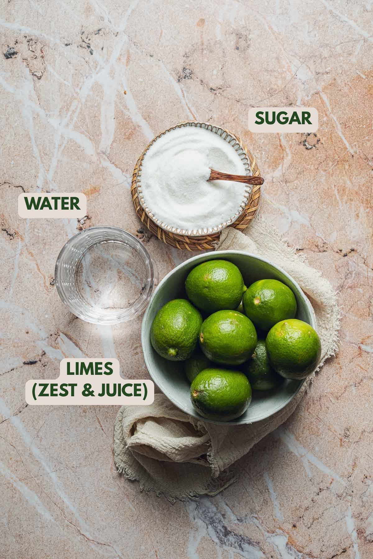 Limes, sugar and water on a surface