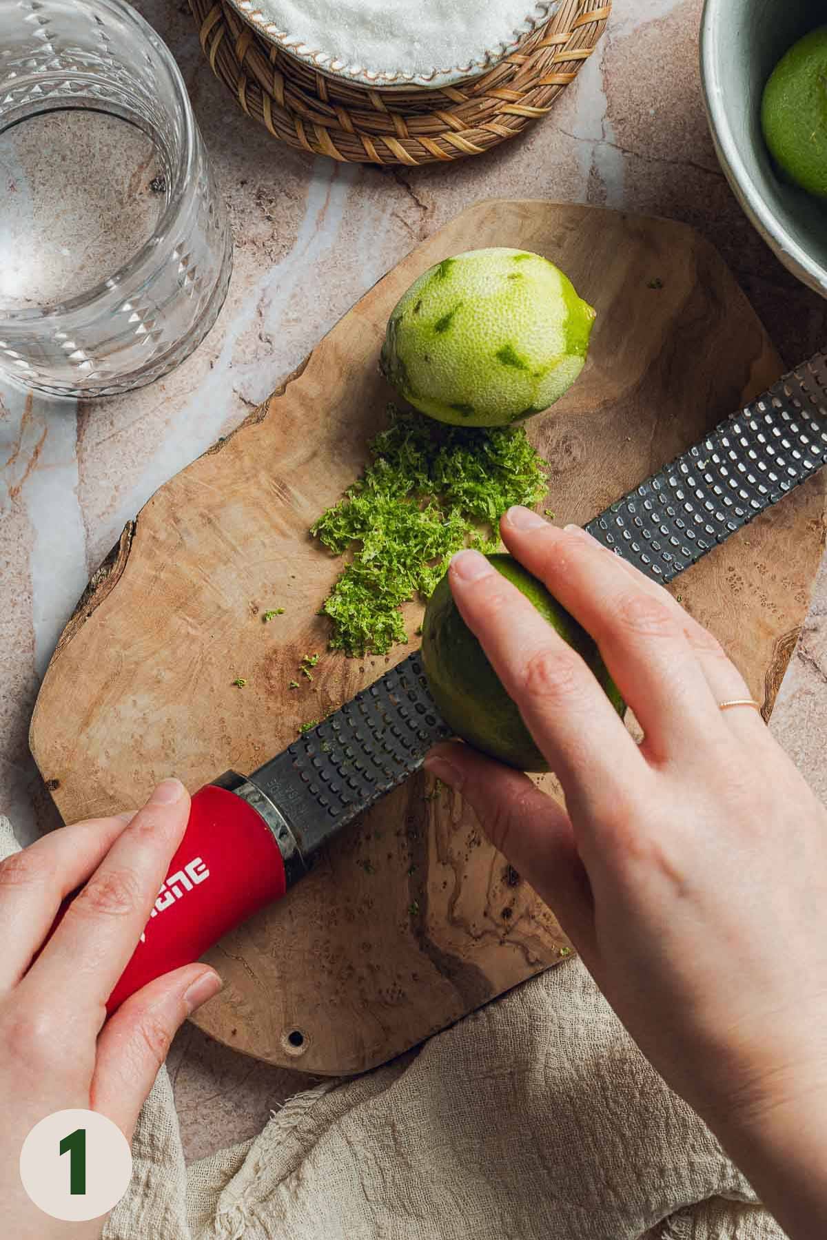 Hands zesting limes